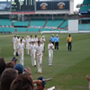 The England team leave the field at the close of play